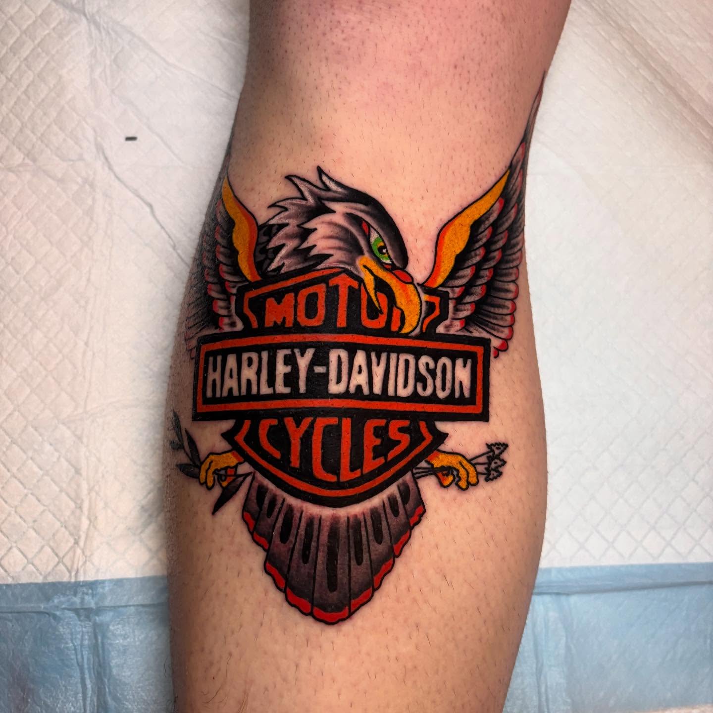 Harley-Davidson eagle logo American traditional tattoo on the forearm by ๐๐ซ๐ข๐ ๐๐ฅ๐ญ๐จ๐ง๐๐ง