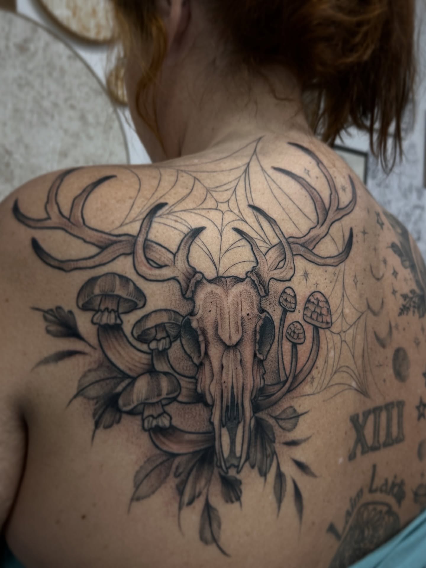 Deer skull and mushrooms realism tattoo on the back by Chloe