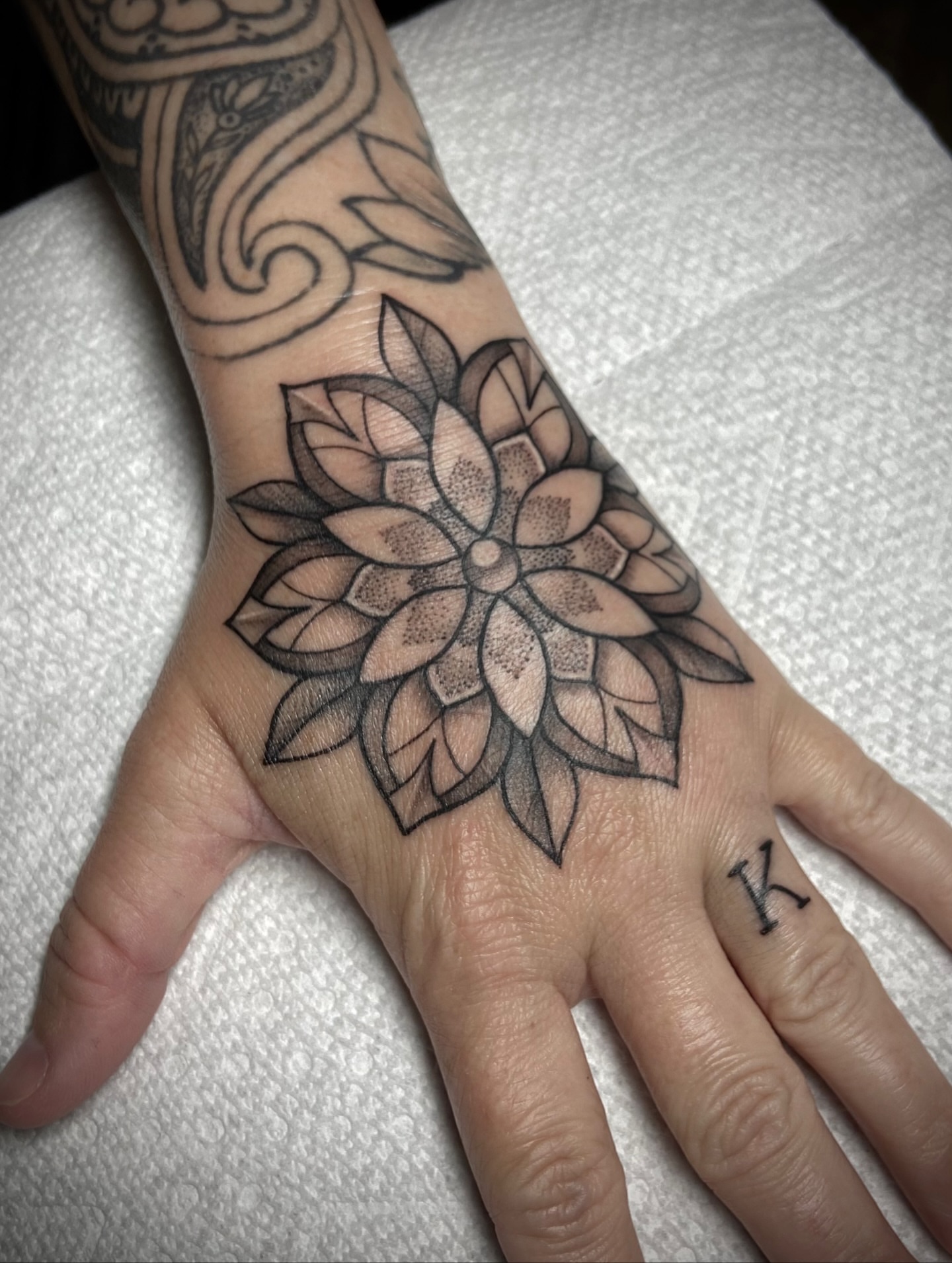 Lotus flower black and grey tattoo on the hand by Zac Byrd