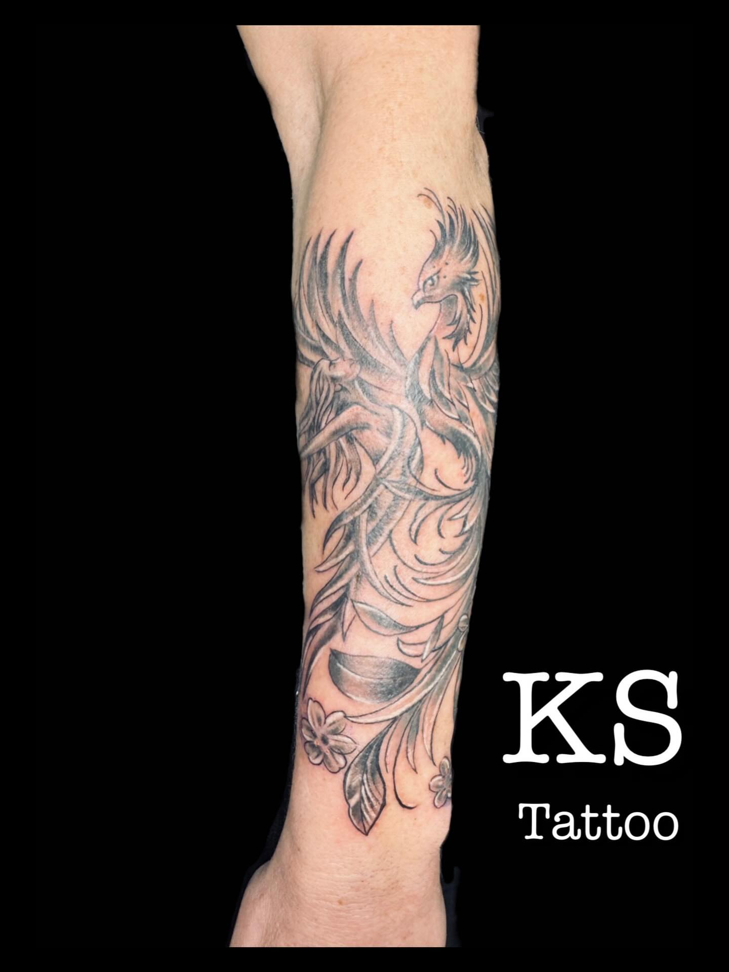 Phoenix black and grey tattoo on the forearm by Karen Smith