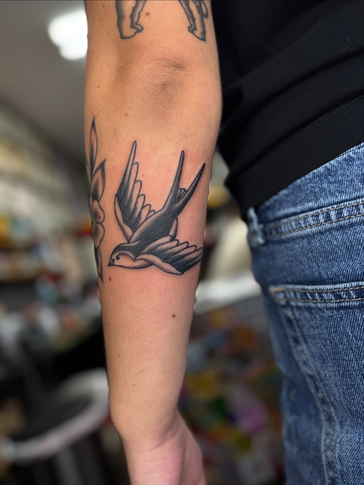 Swallow black and grey tattoo on the forearm by Sarah Pham