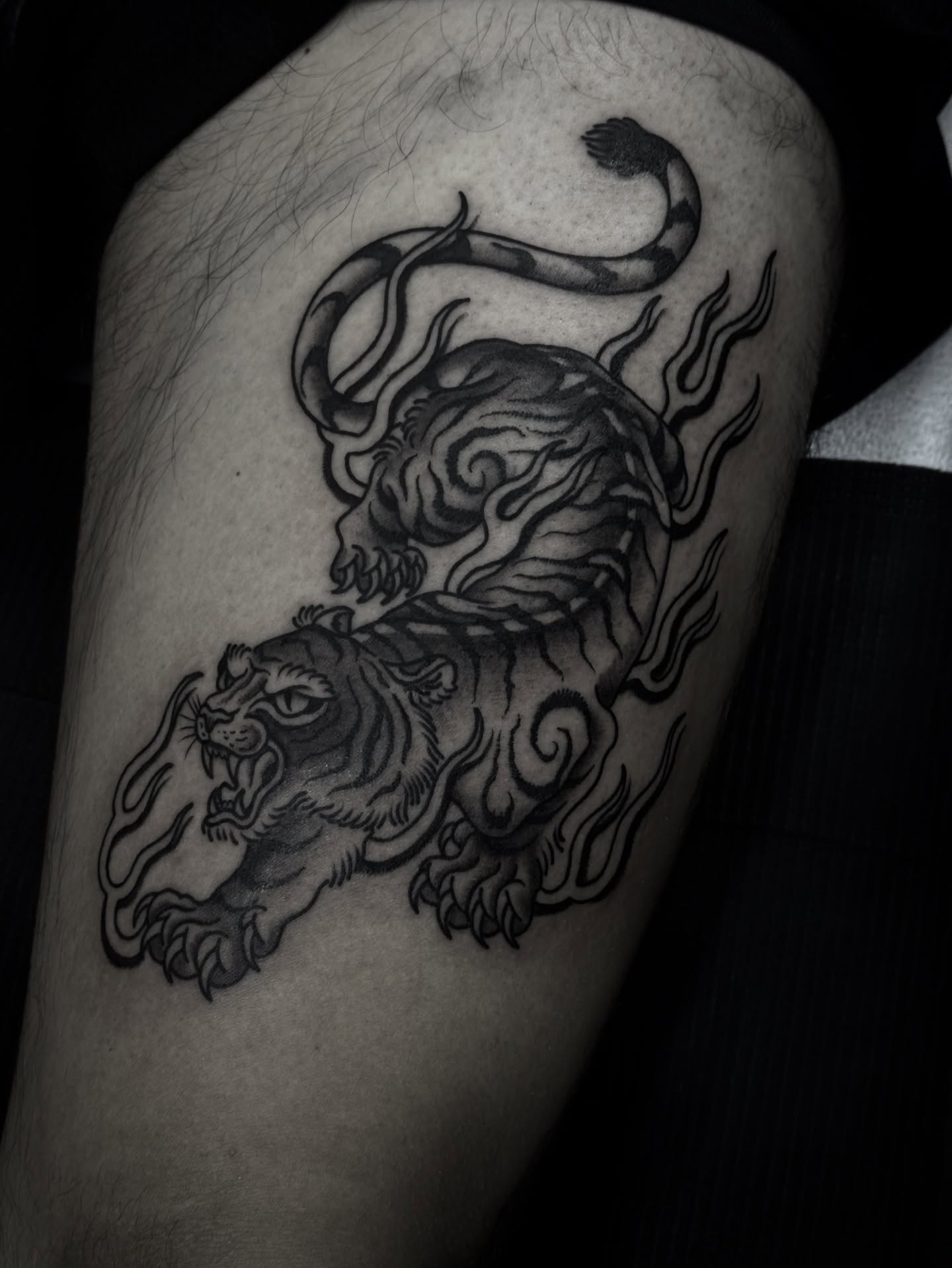 Tiger and dragon black and grey tattoo on the thigh by Ally noel