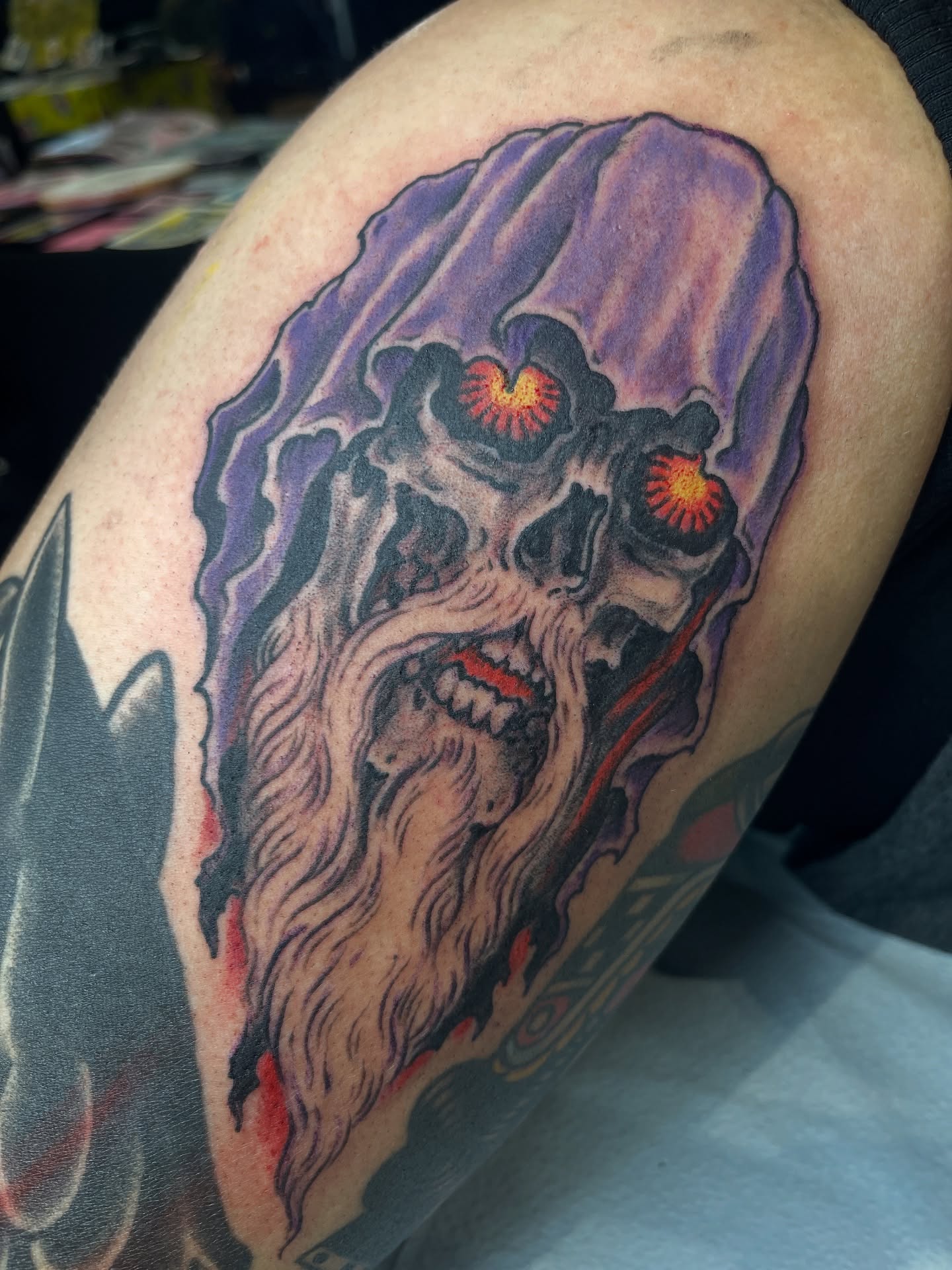 Skull with glowing eyes dark realism tattoo on the thigh by Mike Wilson