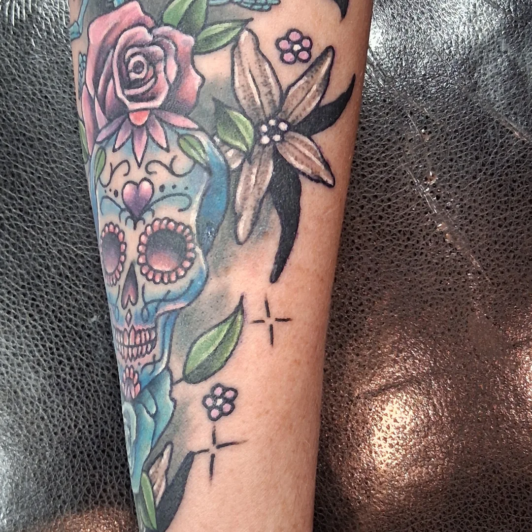 Sugar skull with flowers American traditional tattoo on the forearm by Dave Johnson, Billings, Montana