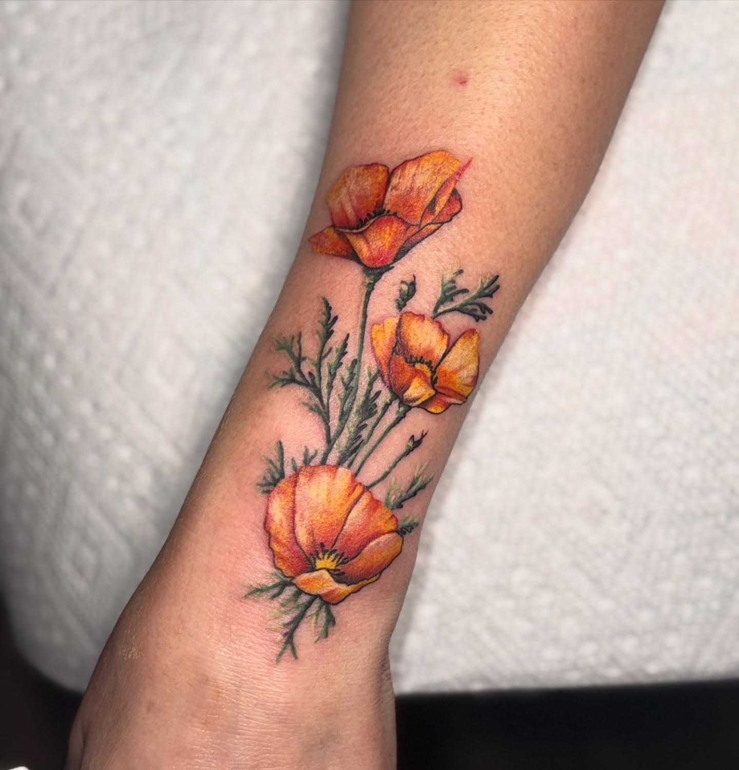 California poppies realism tattoo on the forearm by Lyndze Masters