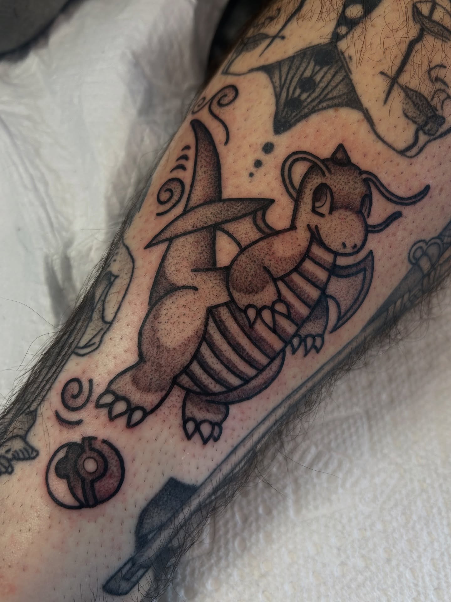 Dragonite black and grey tattoo on the forearm by Lilly Binns