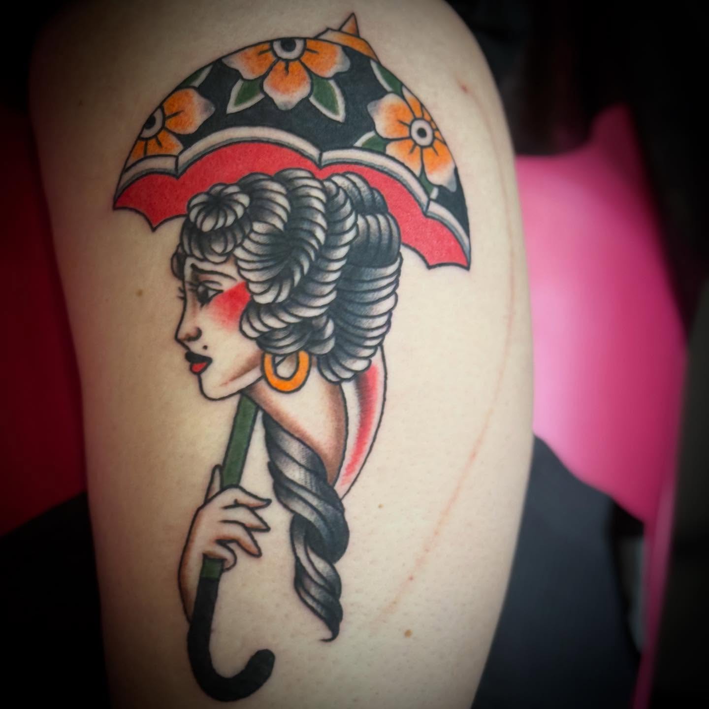 Woman with umbrella American traditional tattoo on the upper arm by ArJay Smith
