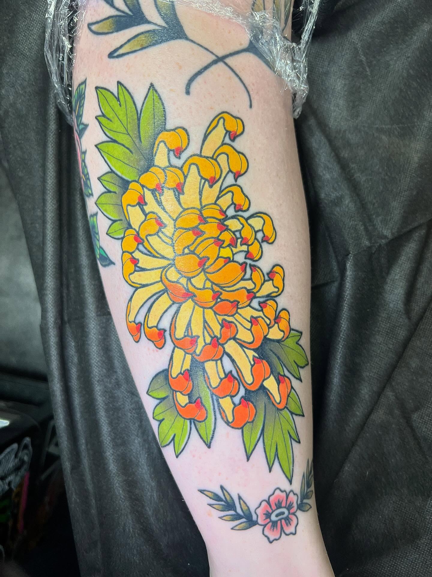 Chrysanthemum bouquet American traditional tattoo on the forearm by Taylor Estrella