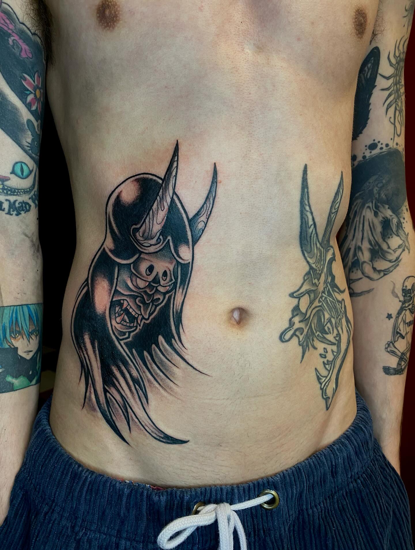 Demon mask dark realism tattoo on the ribs by Jonah