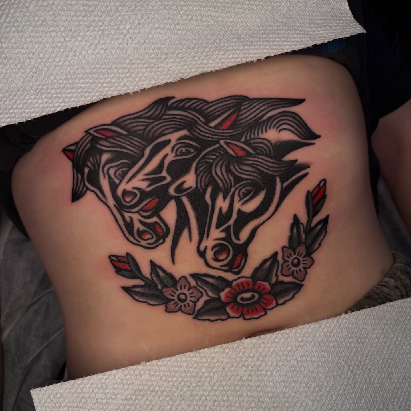Horses and flowers American traditional tattoo on the thigh by Erin Chambers