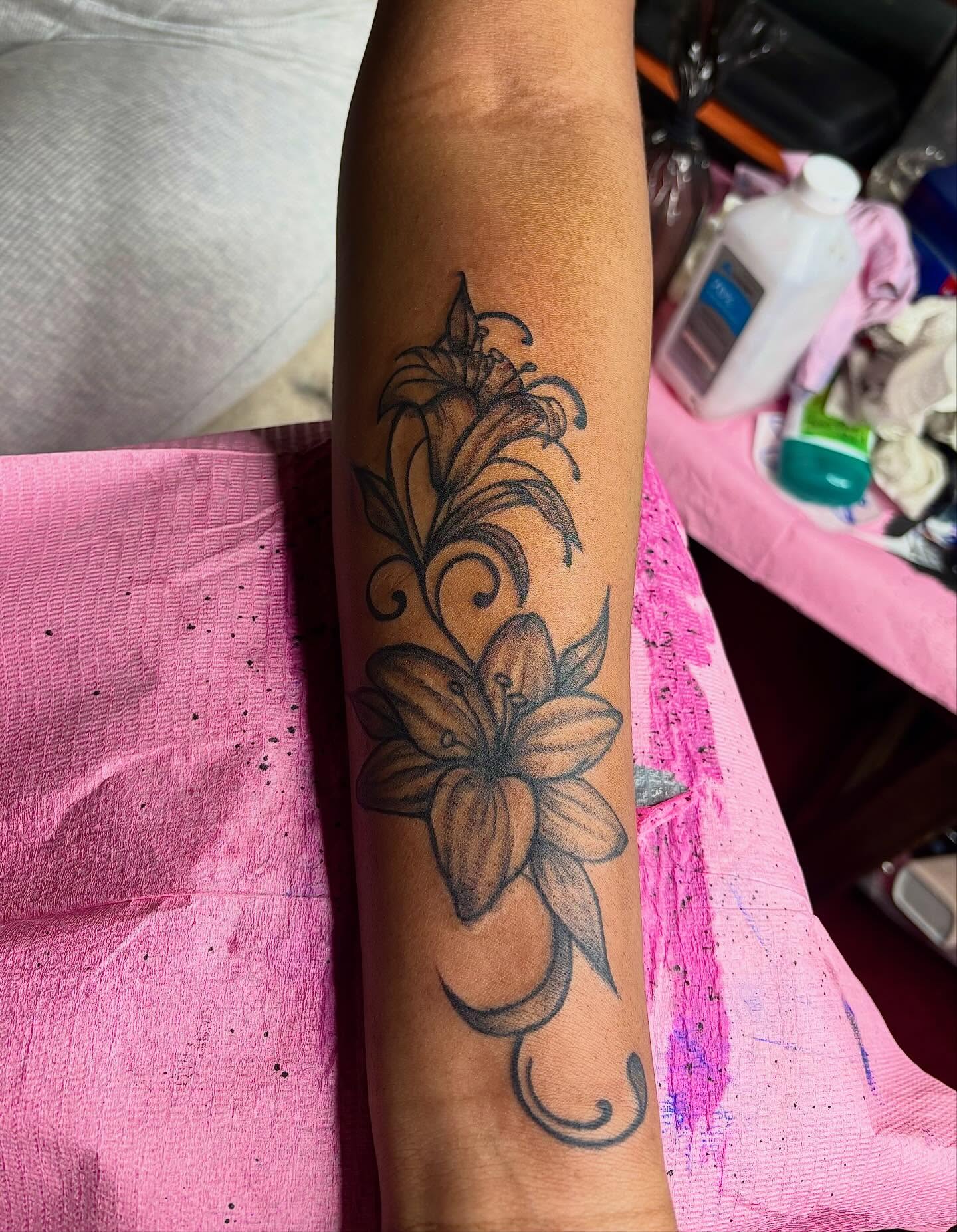Lily black and grey tattoo on the forearm by Barbinks Studio🎀