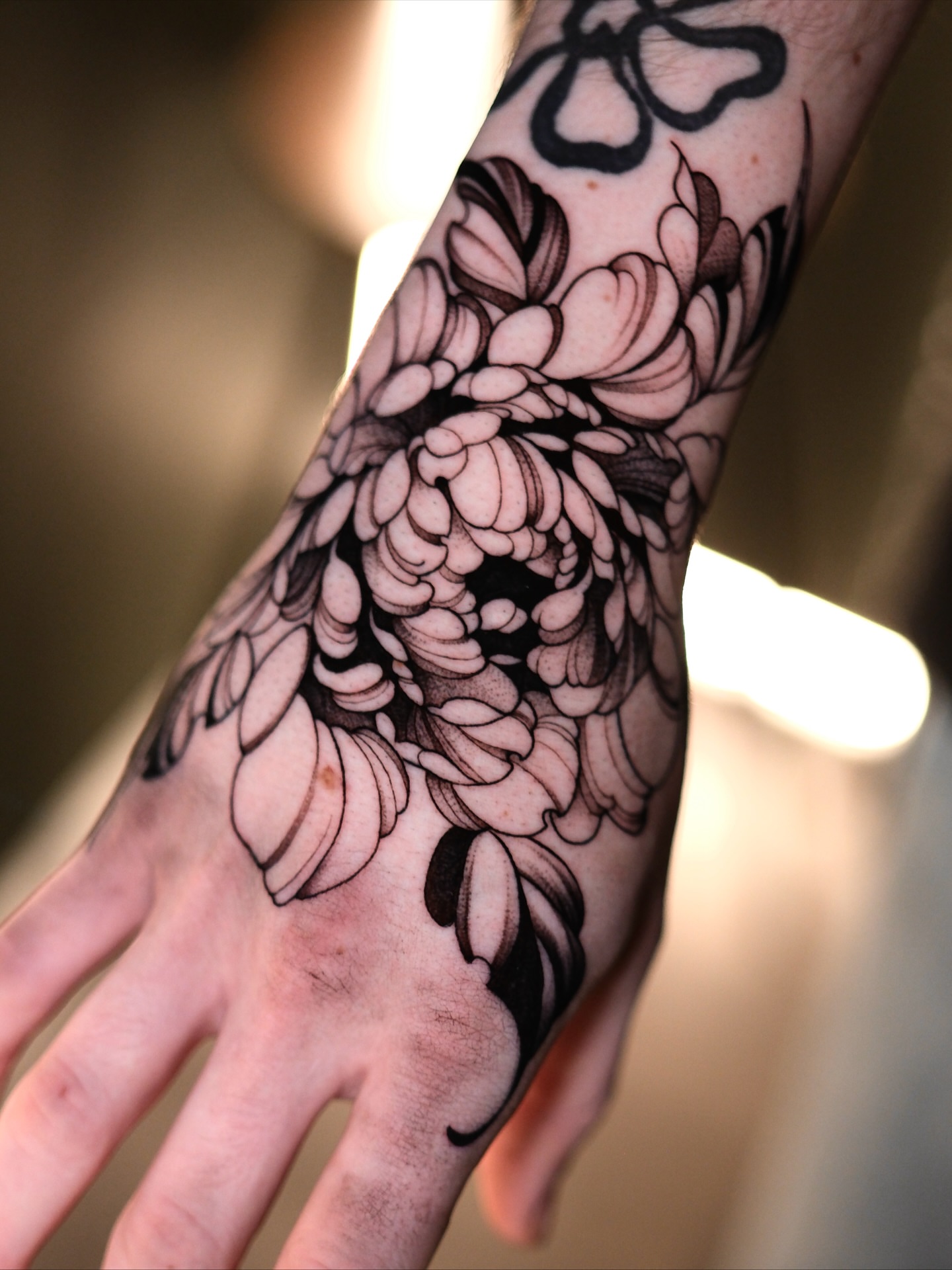 Chrysanthemum black and grey tattoo on the forearm by IVY
