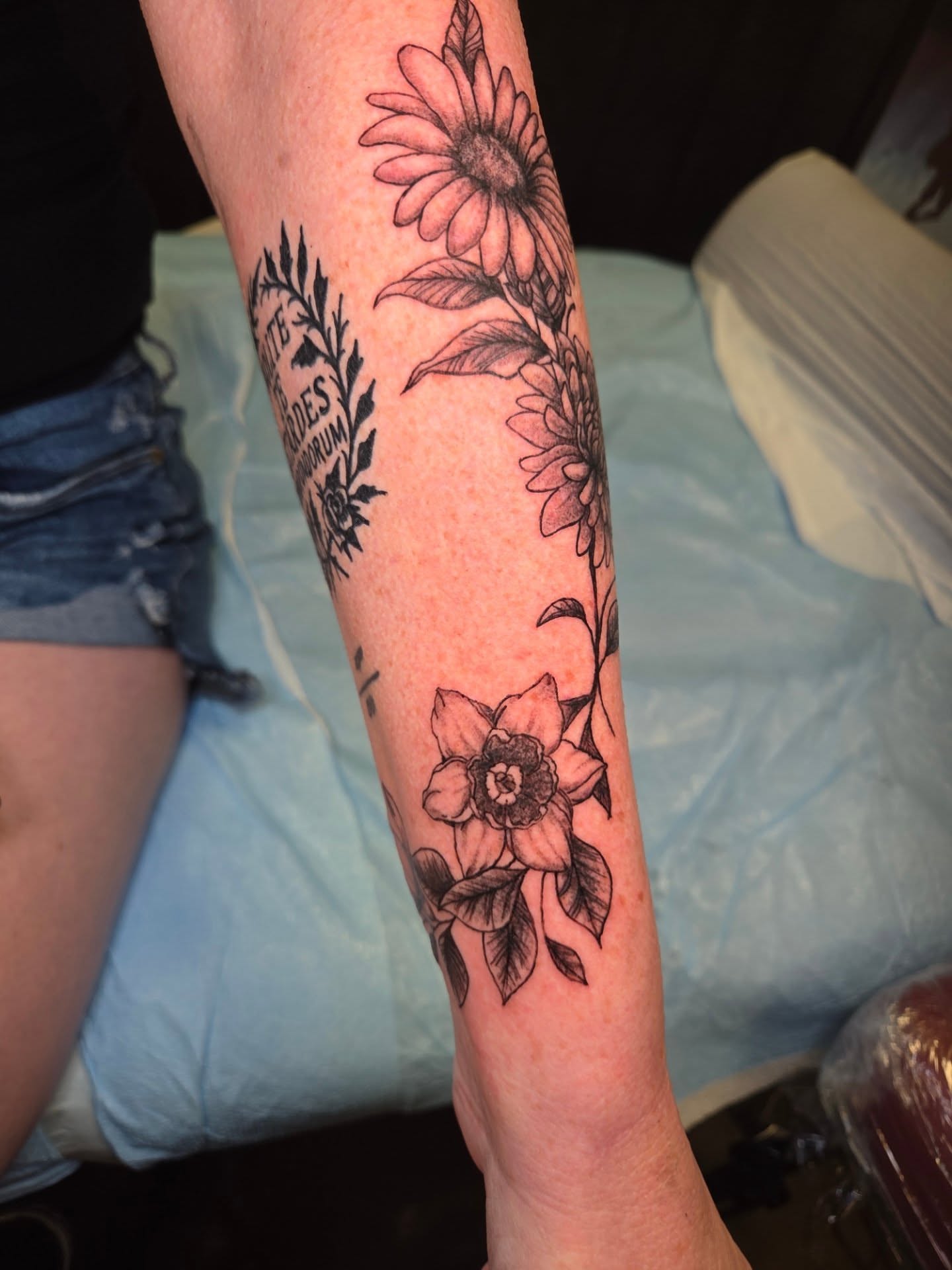 Floral arrangement black and grey tattoo on the forearm by Chaz Escobar
