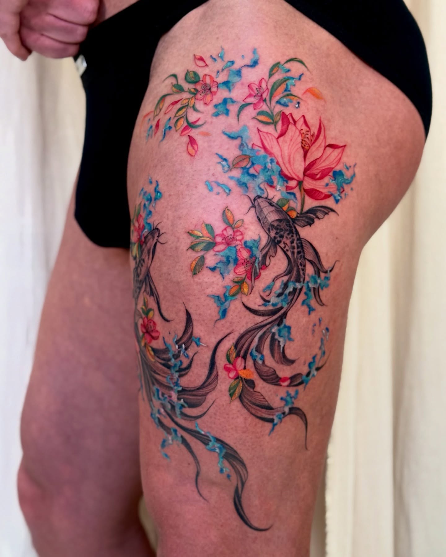 Koi fish and flowers watercolor tattoo on the thigh by Dung Ngo