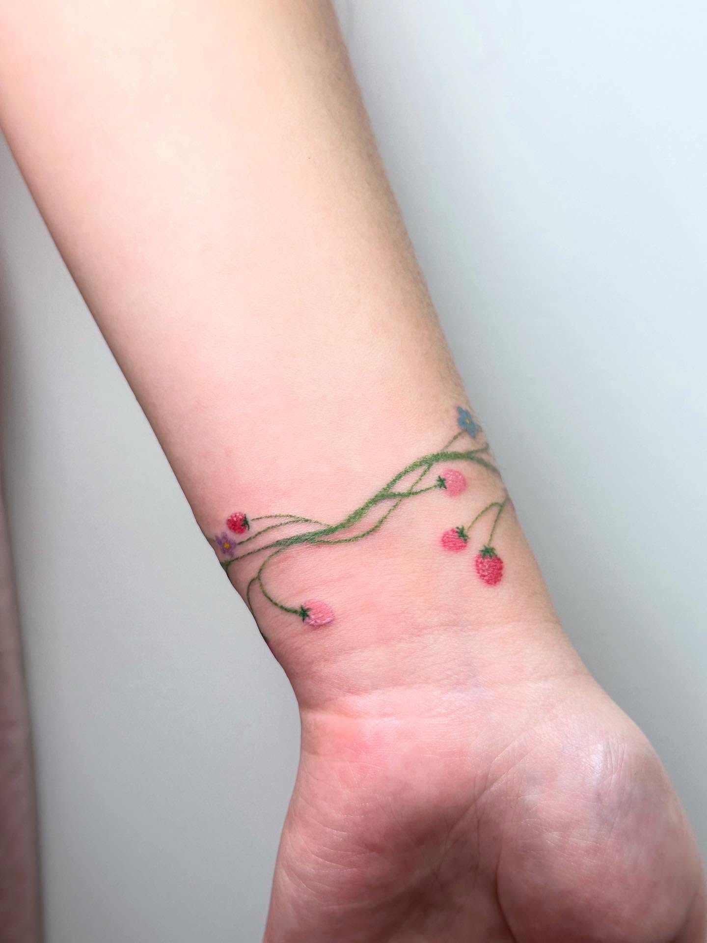 Flower vine fine line tattoo on the forearm by Tomato
