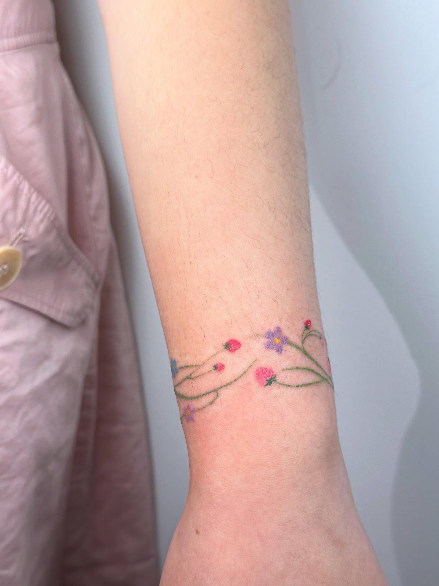 Floral vine fine line tattoo on the forearm by Tomato
