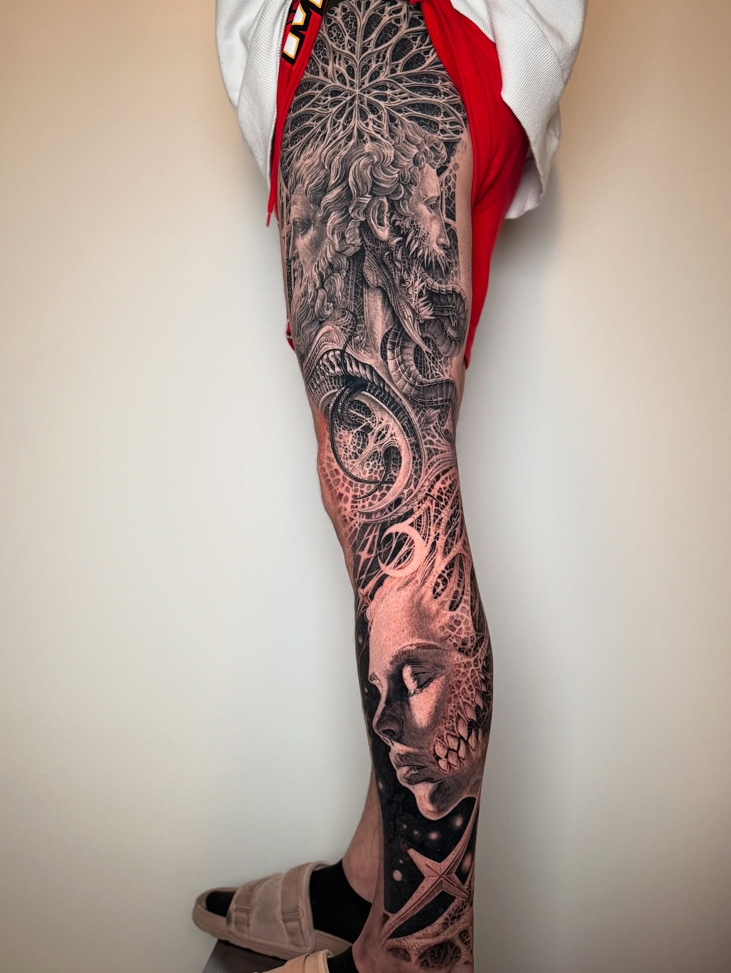 Abstract face with intricate patterns realism tattoo on the leg by Dan Sprague