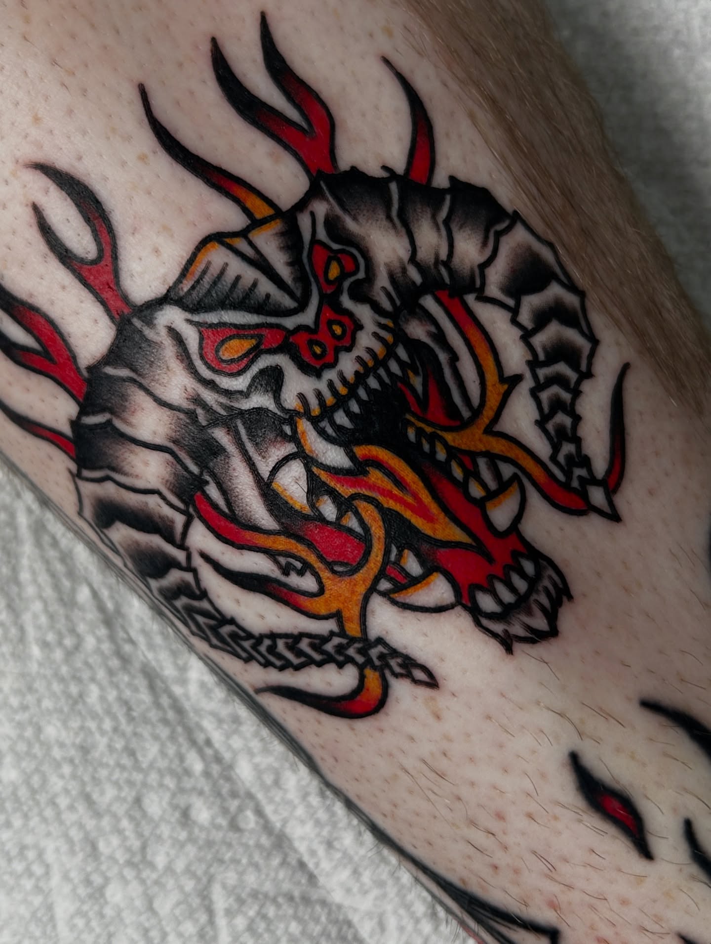 Demon skull American traditional tattoo on the forearm by Dylan James