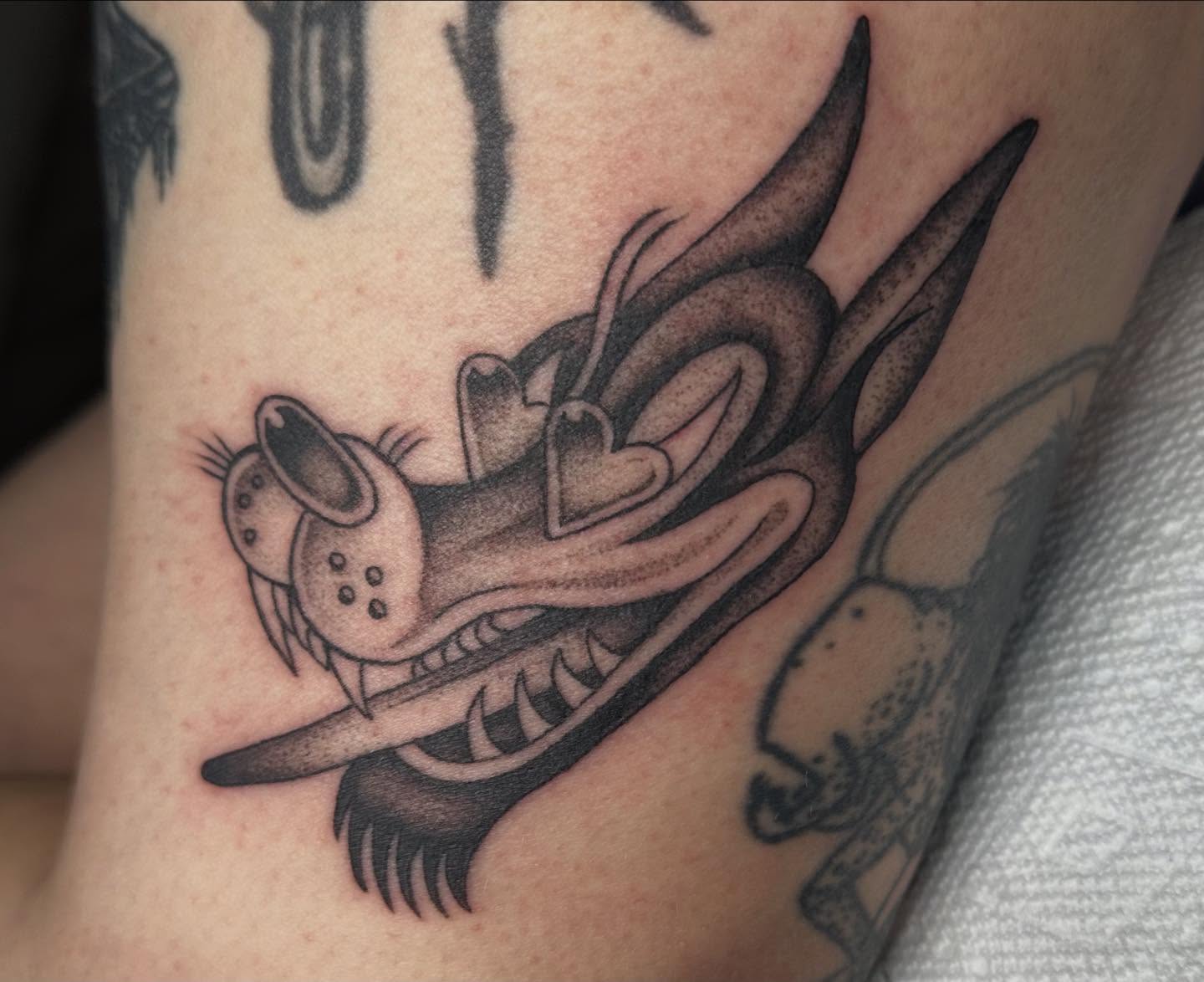 Looney tunes character black and grey tattoo on the forearm by Lia Massari