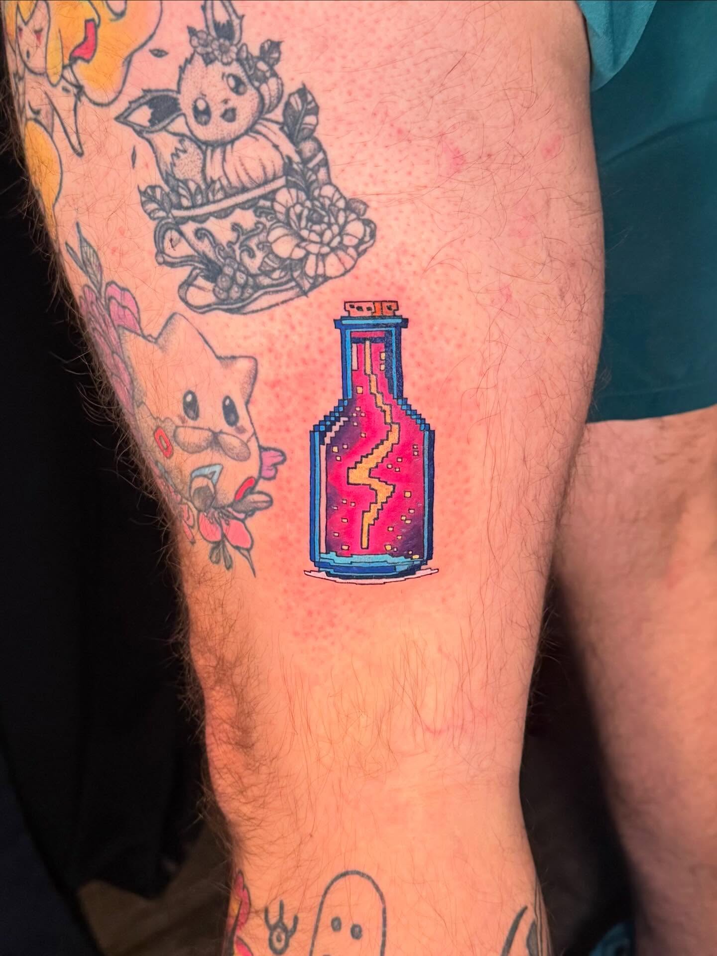Pixelated bottle tattoo on the forearm by Damon Moore