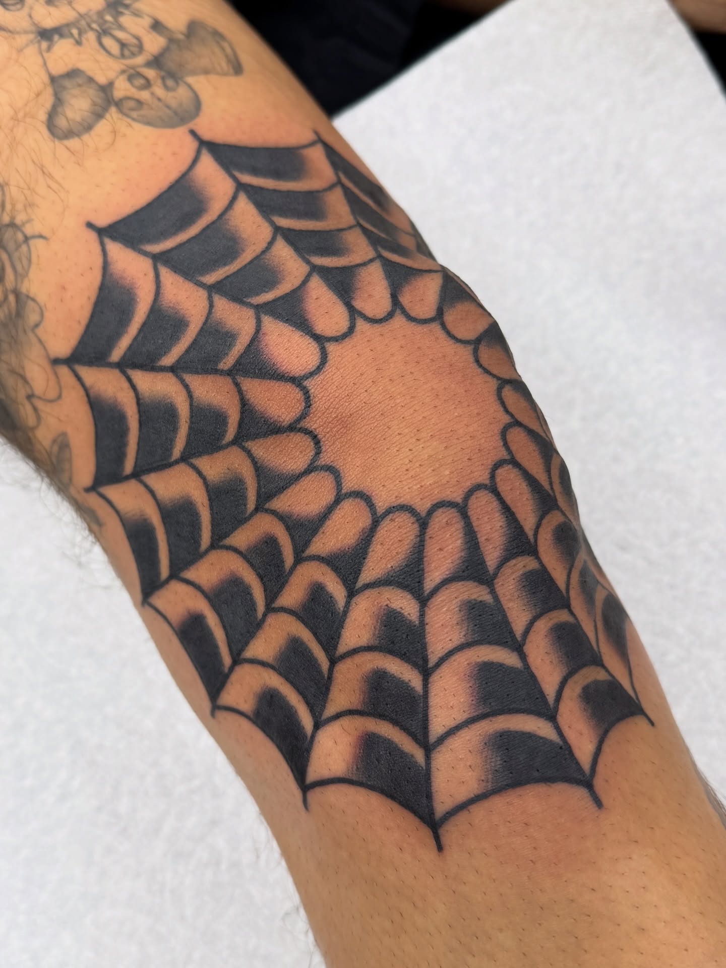 Spiderweb geometric tattoo on the forearm by Joey Burdette Tattoos