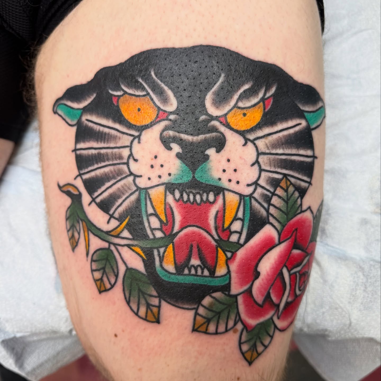 Panther and roses American traditional tattoo on the thigh by DemianThompson