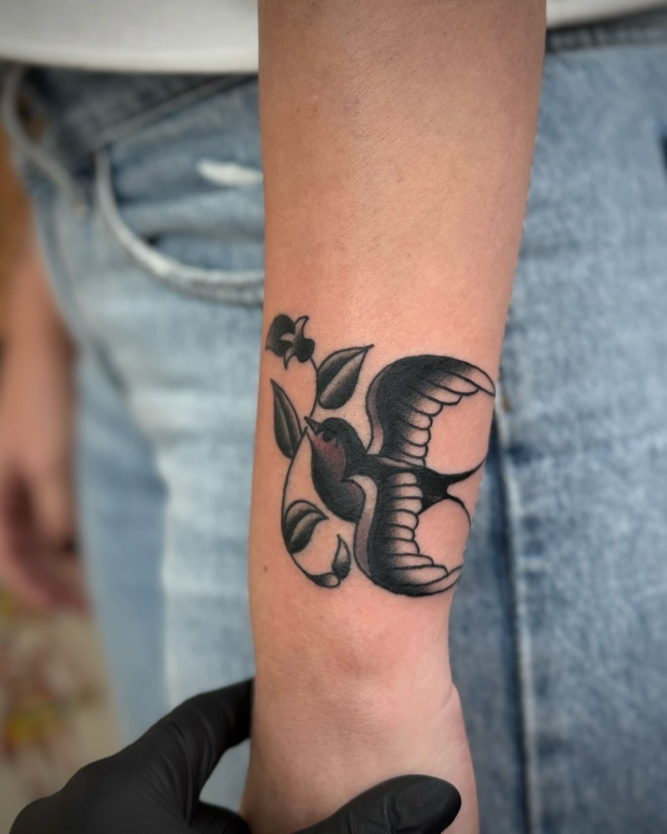 Bird and flower American traditional tattoo on the forearm by kalli berry