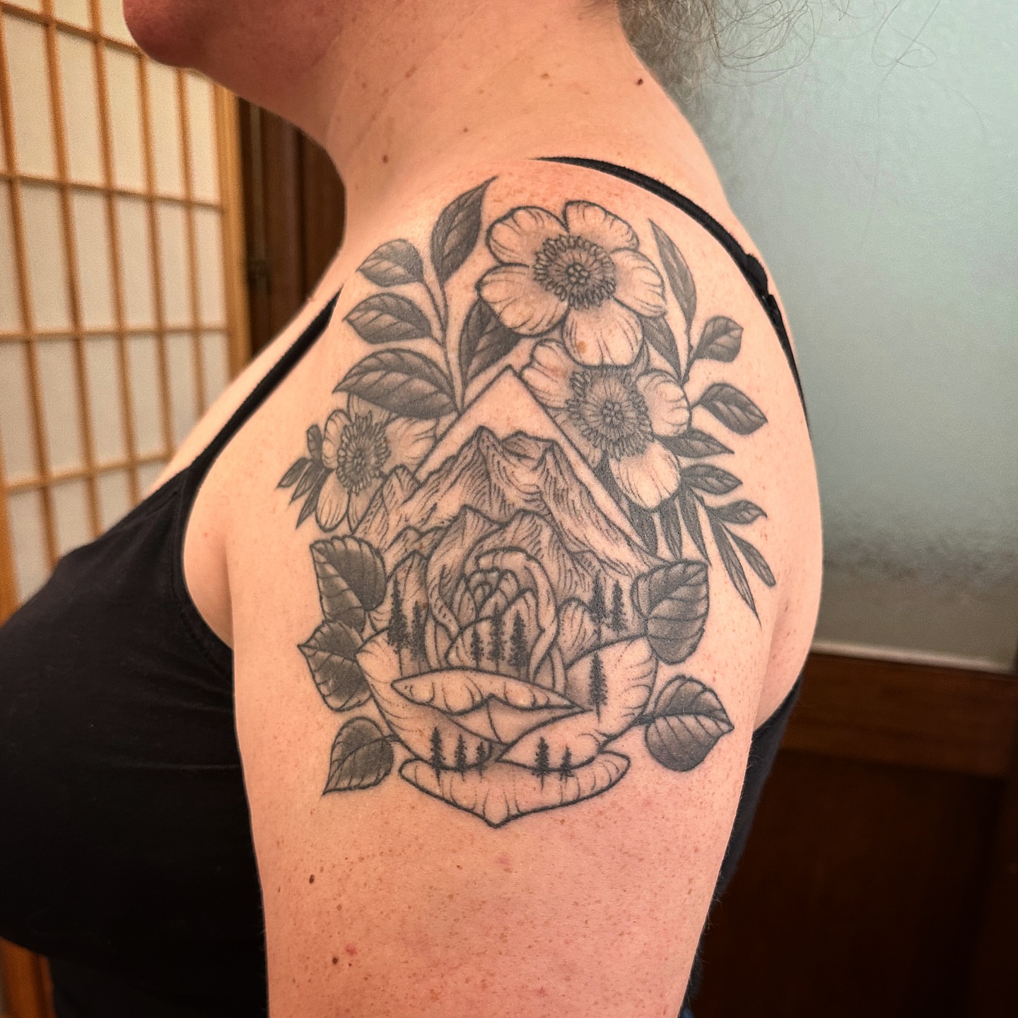 Mountain and flowers black and grey tattoo on the shoulder by Tattooing by Patty Valentine