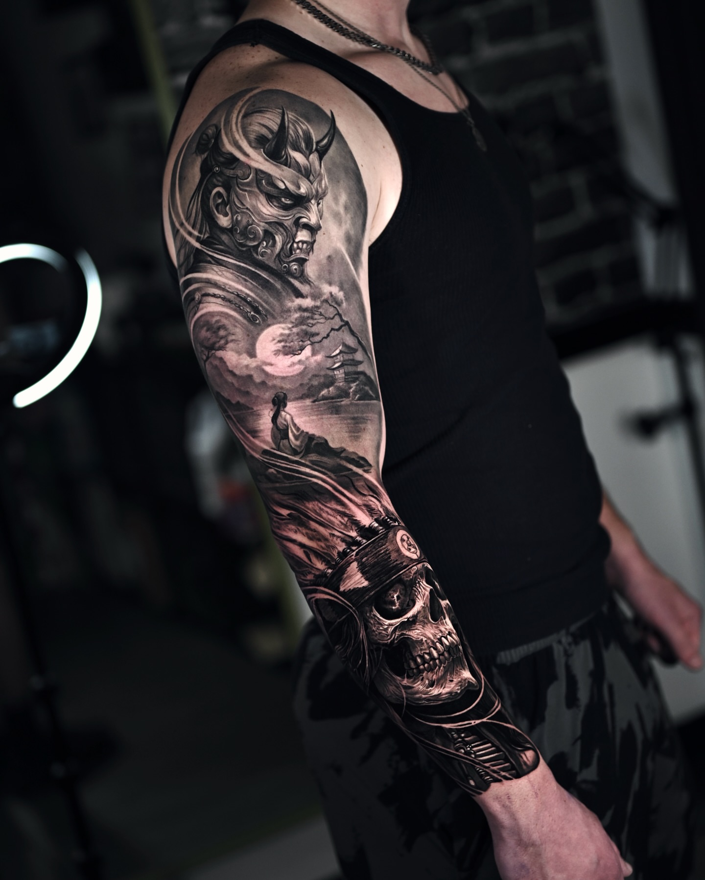 Demon and skull realism tattoo on the upper arm by Marcos Salamanca