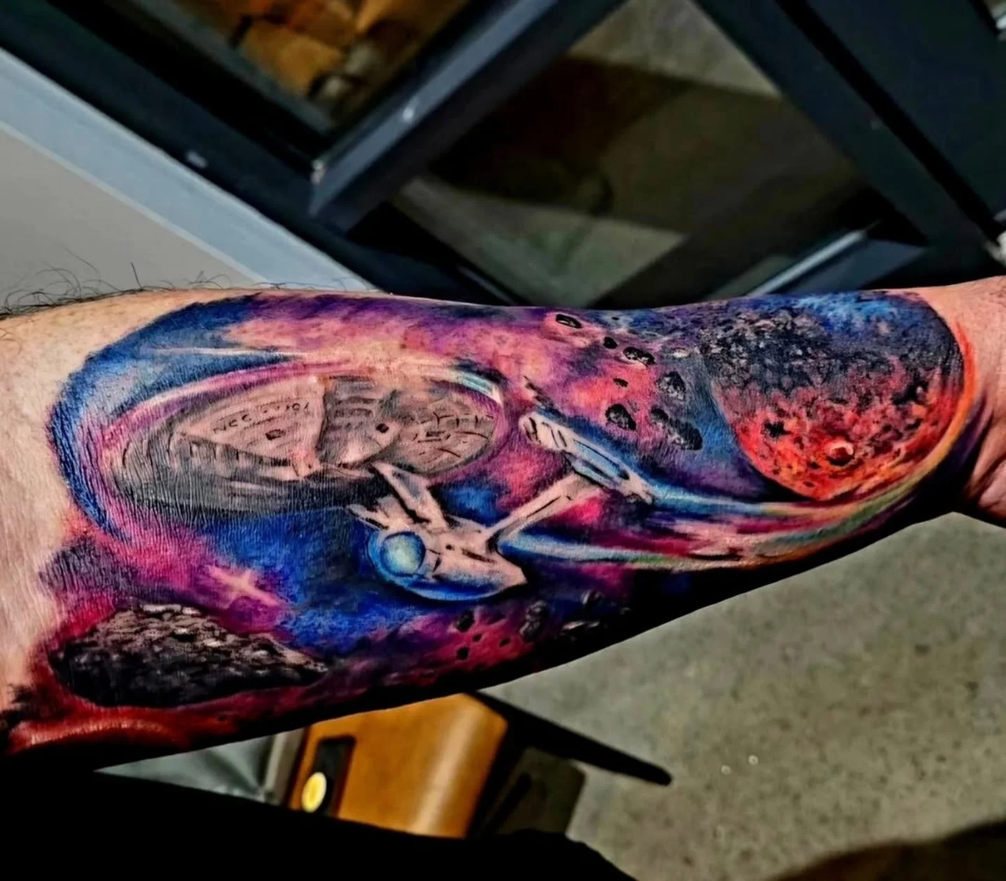 Spaceship in space realism tattoo on the forearm by Drew King
