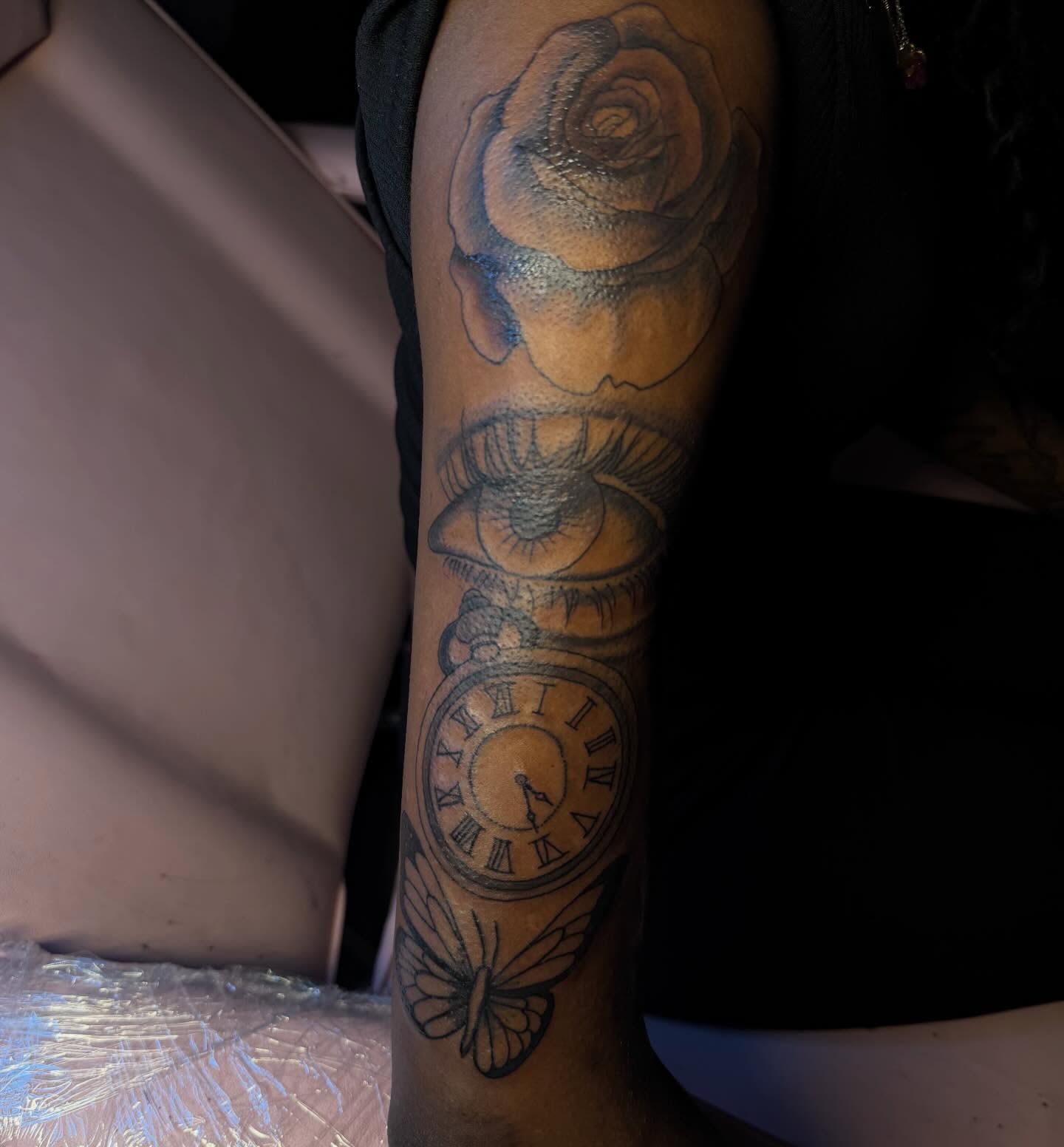 Clock and rose black and grey tattoo on the forearm by Tatted By Layy