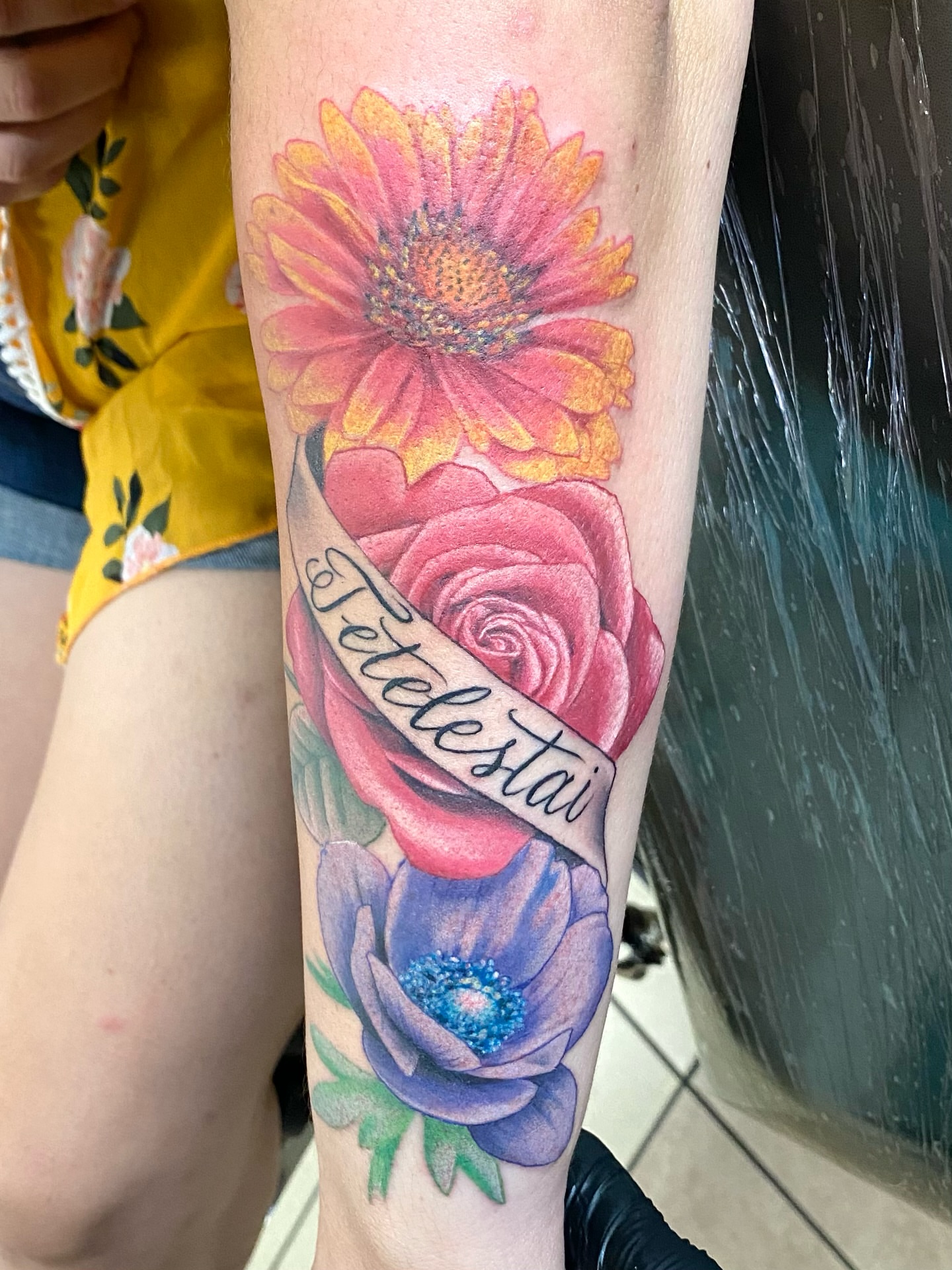Flowers and ribbon realism tattoo on the forearm by Toni🌊