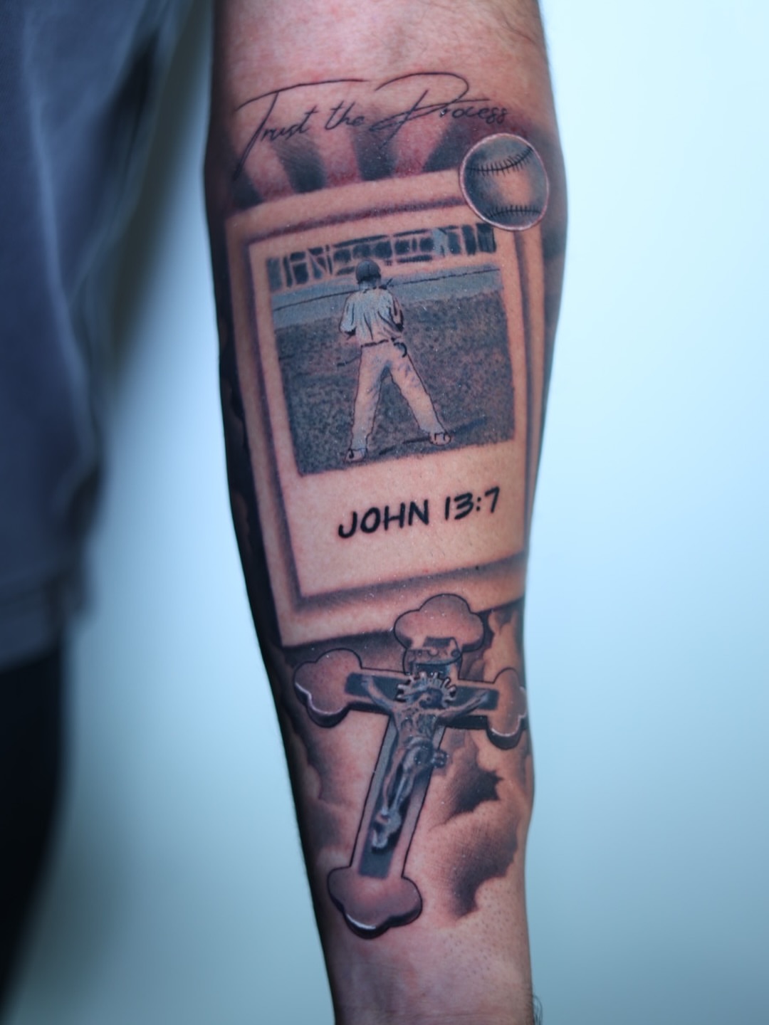 Baseball player and cross realism tattoo on the forearm by Tiago Ink