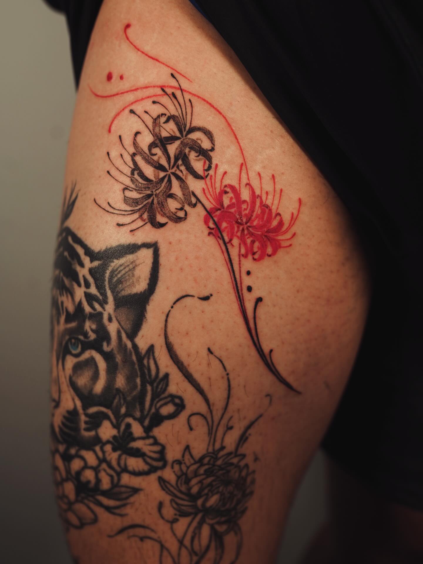 Flower and fish black and grey tattoo on the upper arm by J