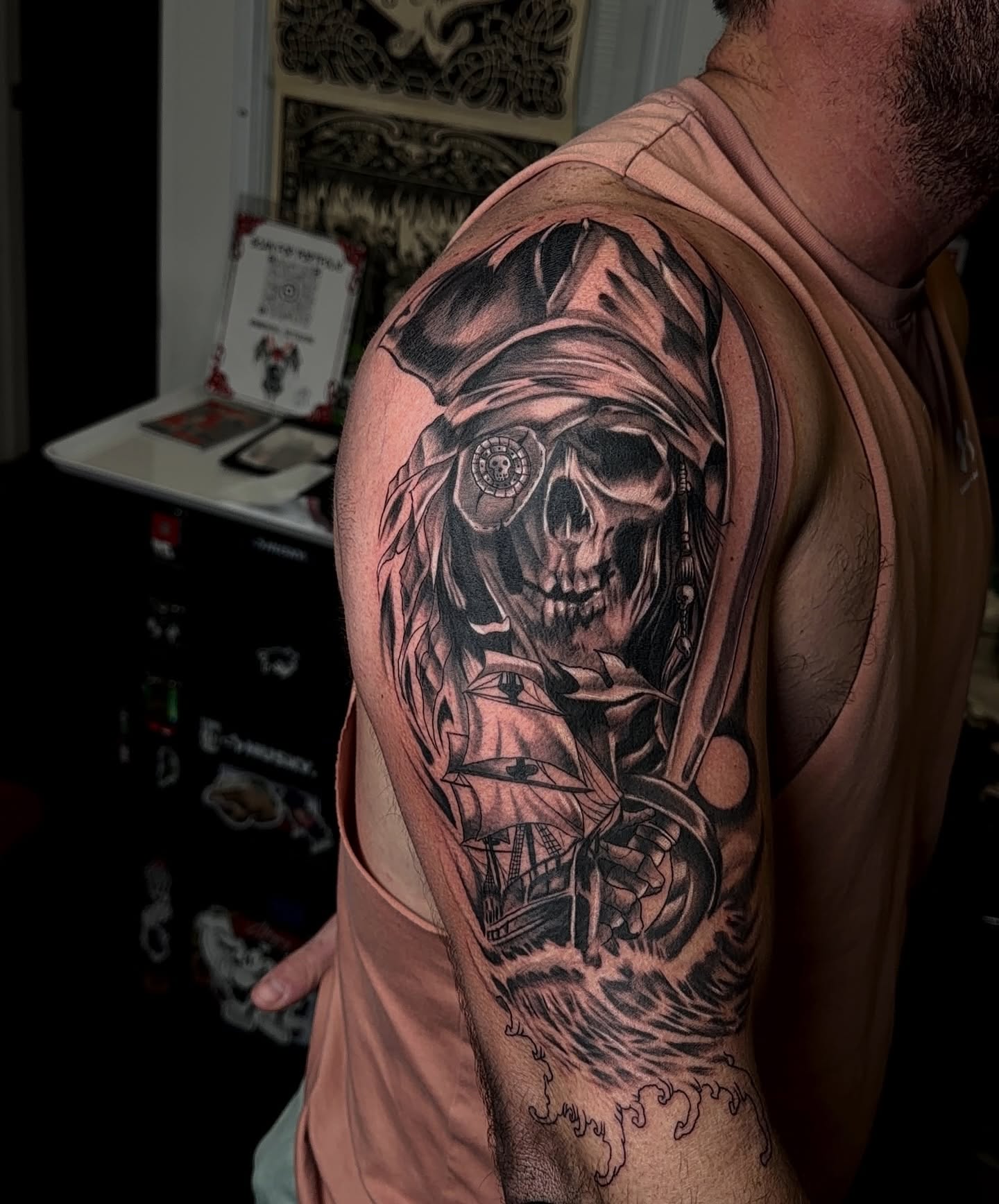 Pirate skull with ship realism tattoo on the shoulder by Denis Seregin