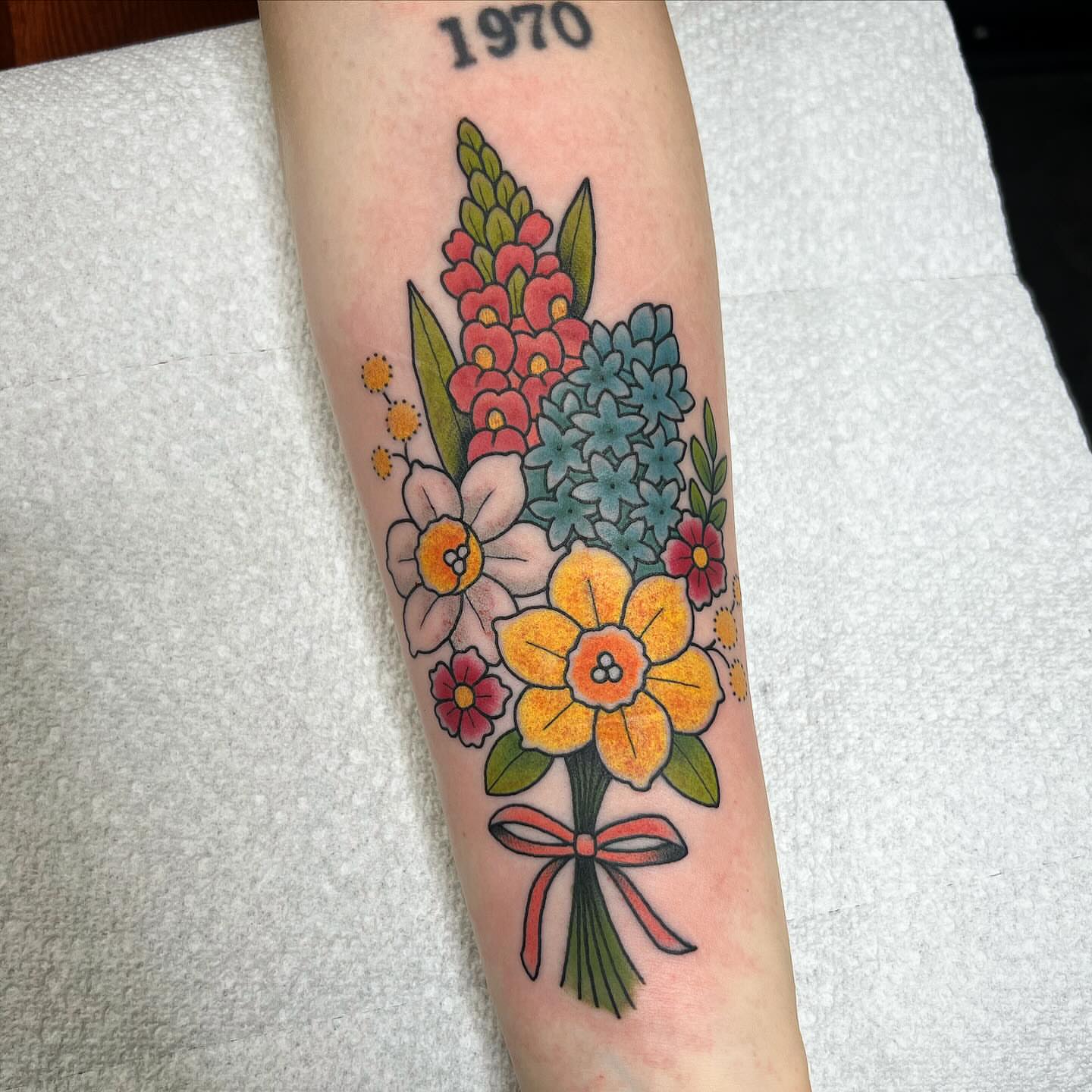 Flower bouquet American traditional tattoo on the forearm by Taylor Estrella