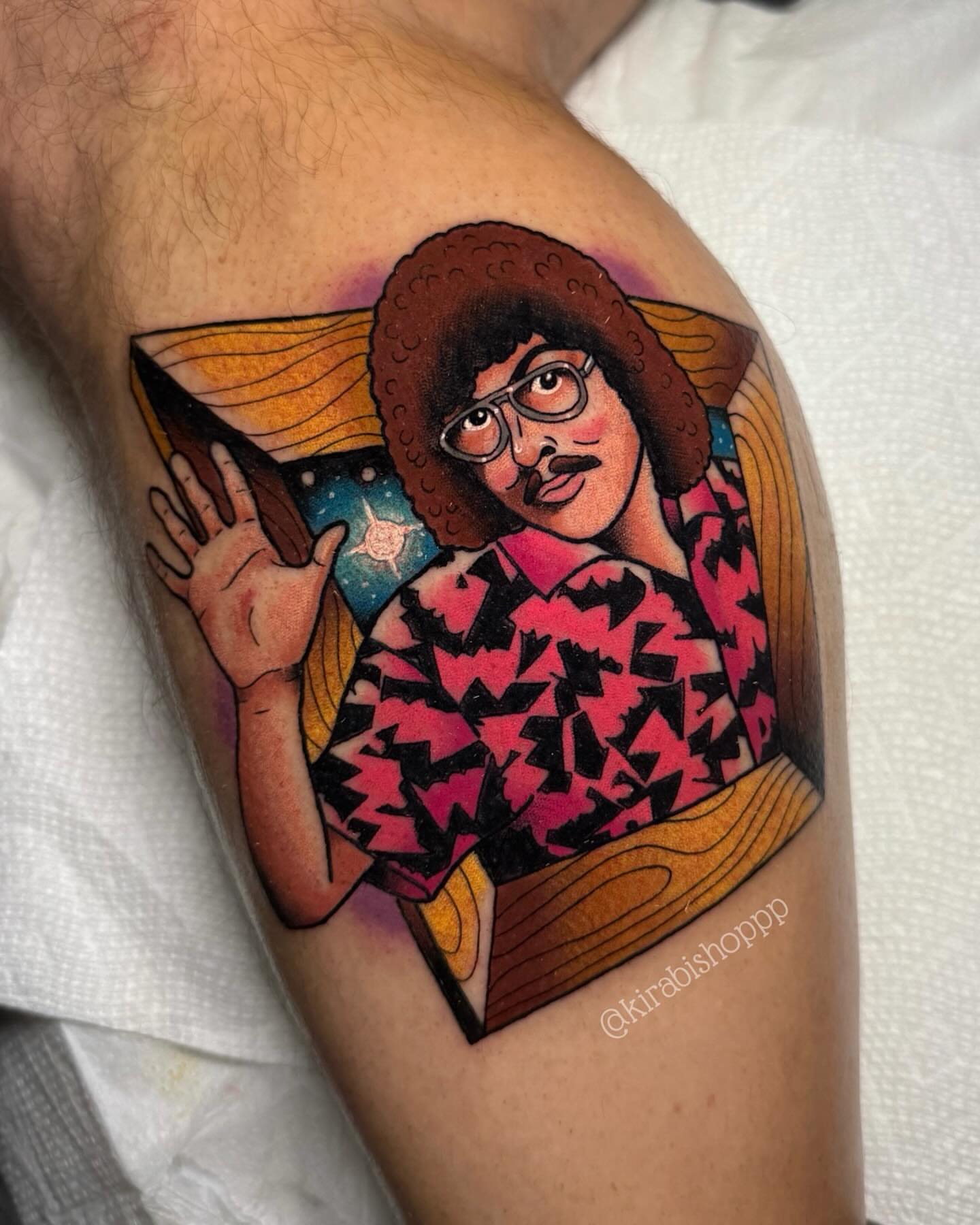 Person with afro and mustache illustrative tattoo on the upper arm by 𝔎𝔦𝔯𝔞 𝔅𝔦𝔰𝔥𝔬𝔭