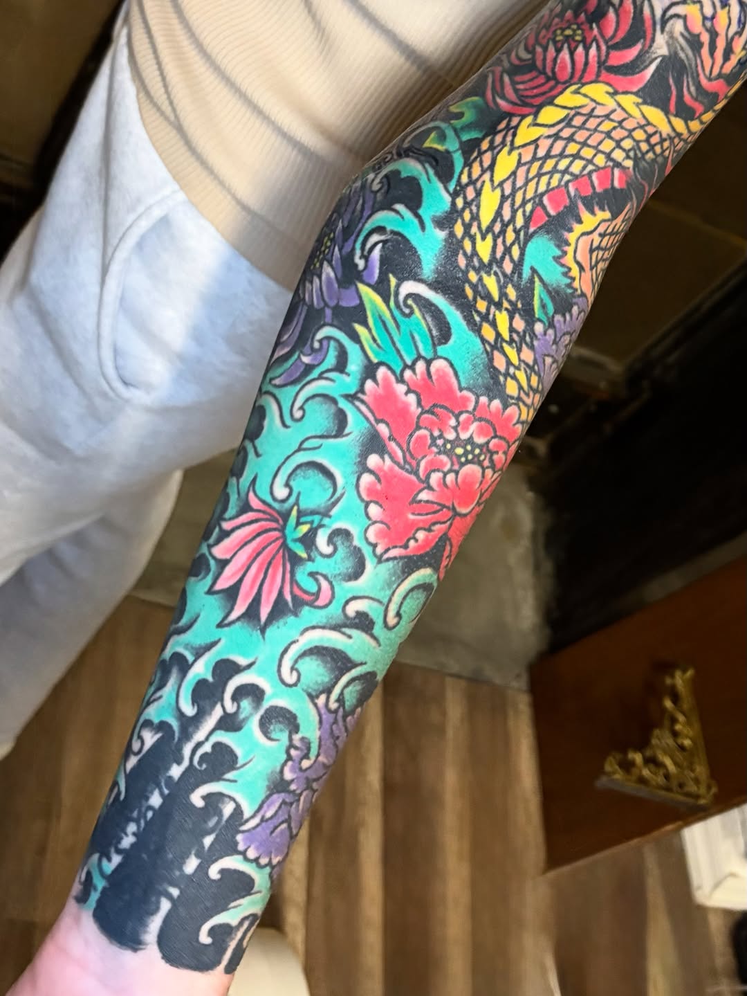 Dragon and flowers Japanese tattoo on the forearm by Gabi Elia
