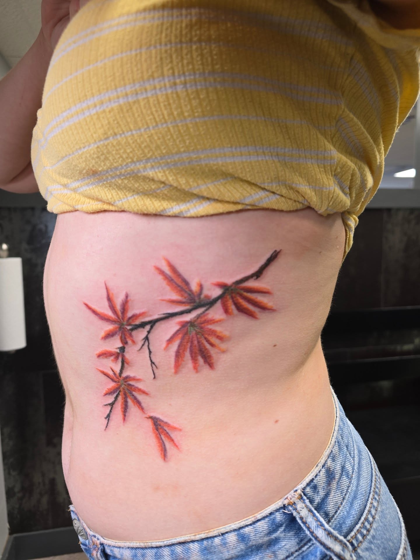 Cherry blossom branch realism tattoo on the ribs by Karen Cain