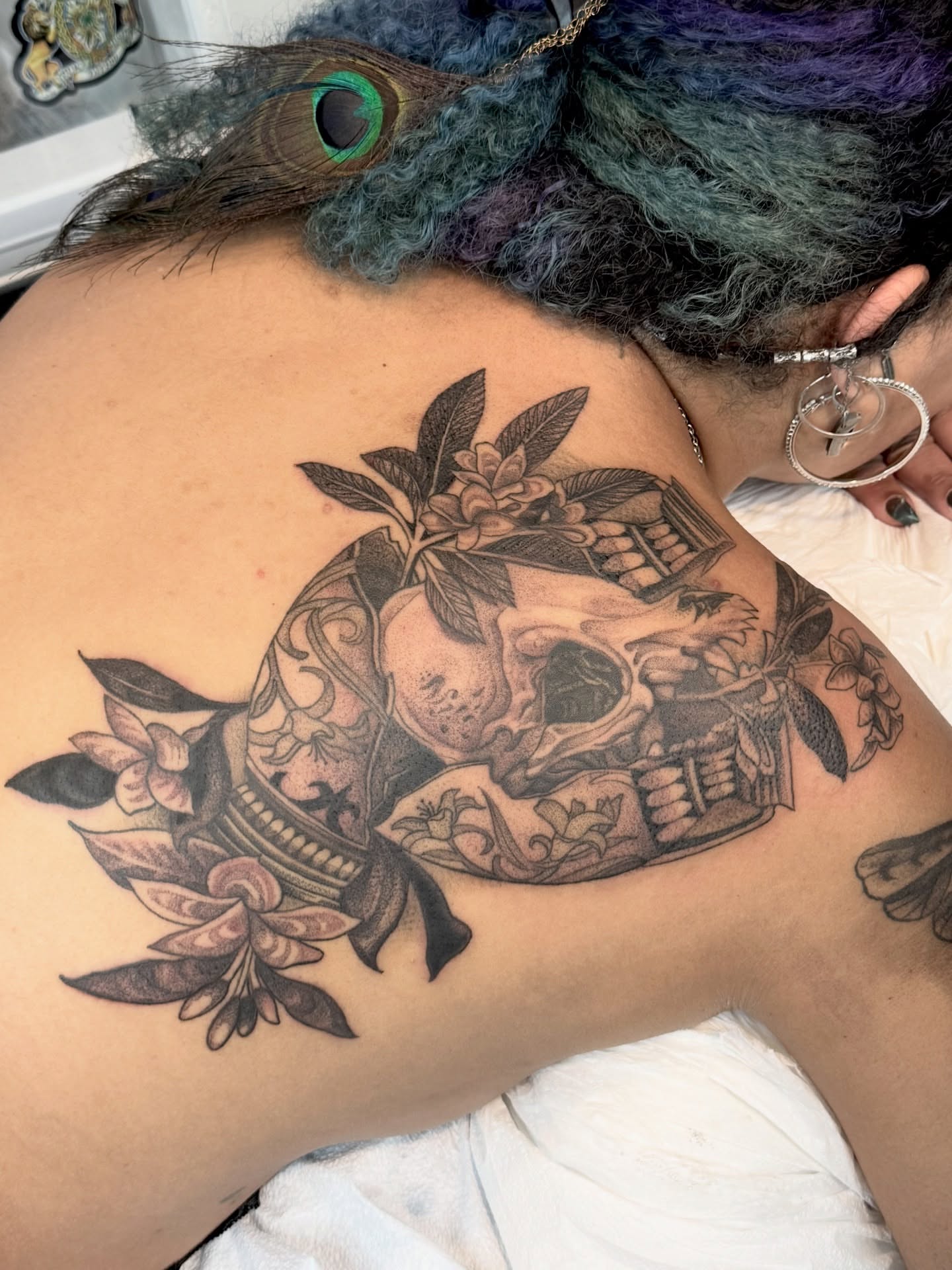 Skull and flowers realism tattoo on the shoulder by Erick Mendivil