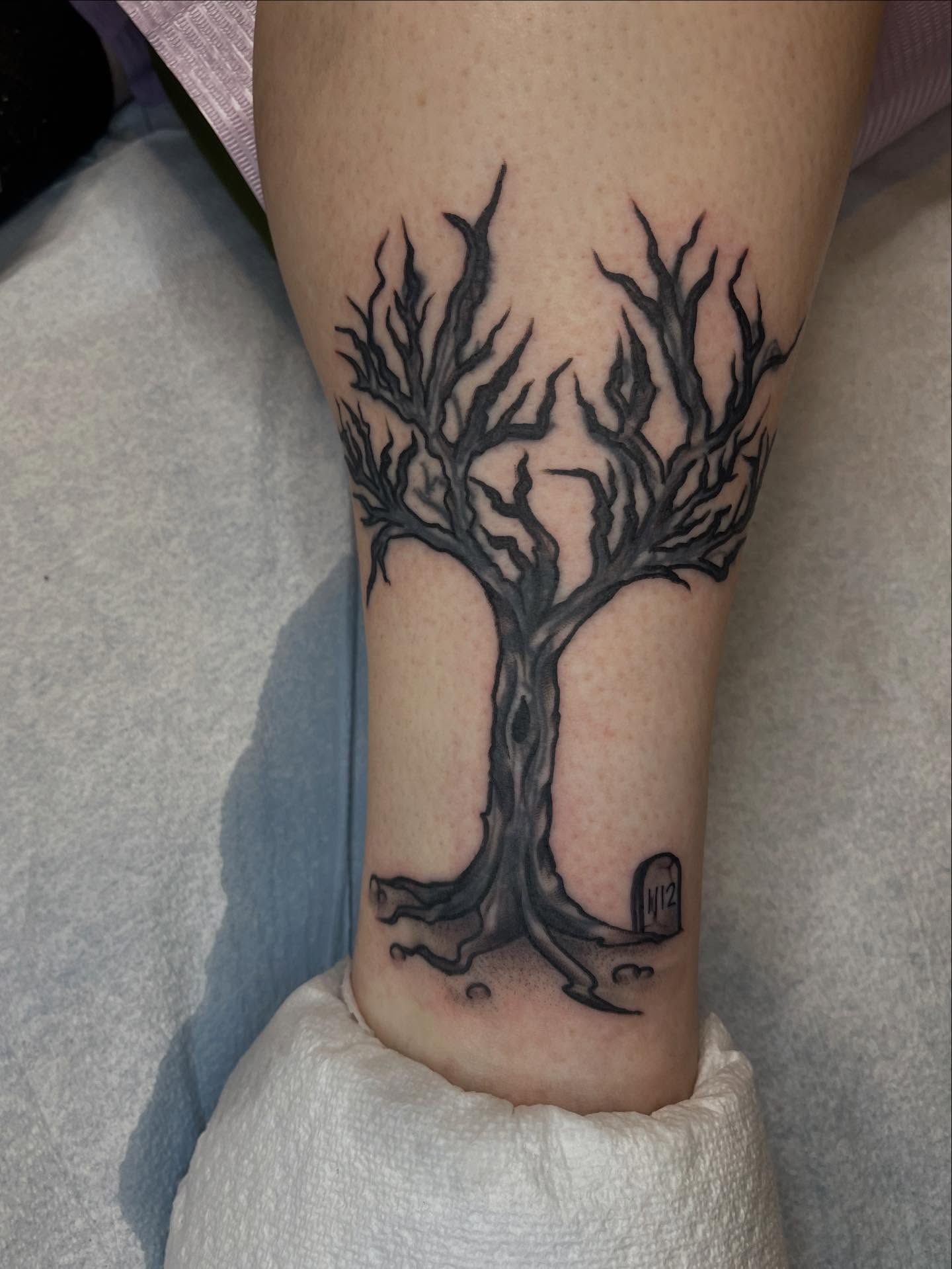 Bare tree black and grey tattoo on the calf by Allison Gallagher