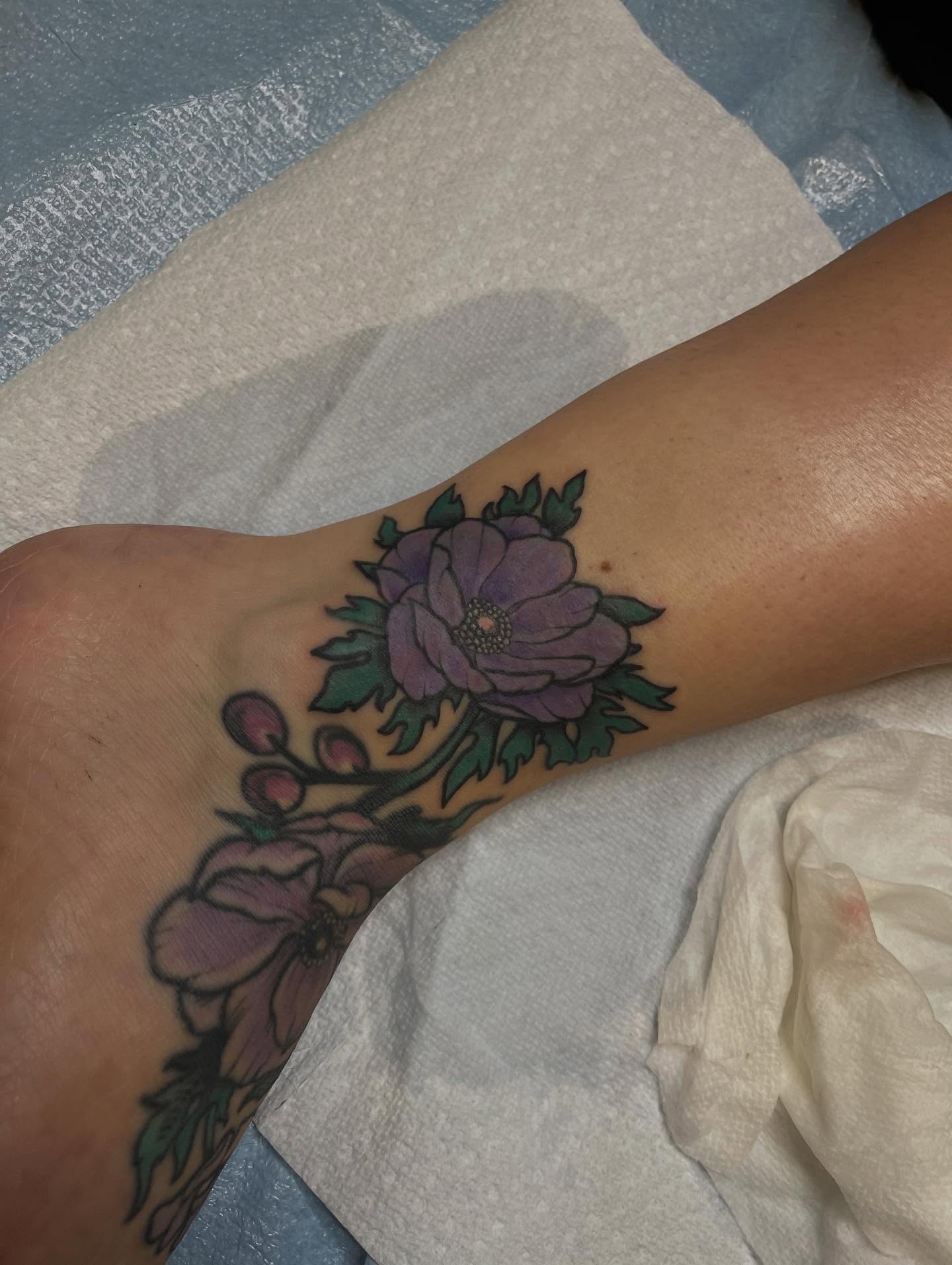 Purple flowers new school tattoo on the forearm by Allison Gallagher
