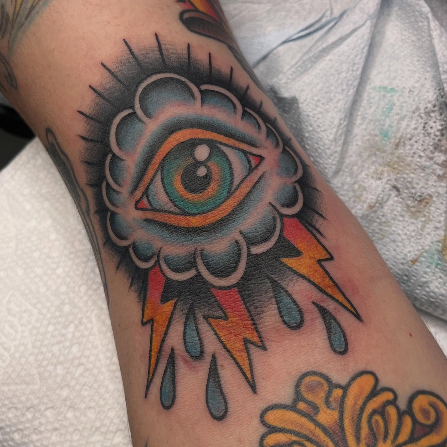 Eye with lightning bolts American traditional tattoo on the forearm by ๐๐ฎ๐ฌ๐ญ๐ข๐ง ๐๐จ๐ฐ๐๐ซ๐, Oakland, California