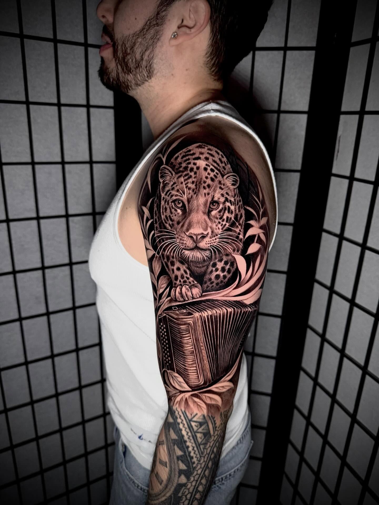 Leopard realism tattoo on the upper arm by Daniel Ruiz