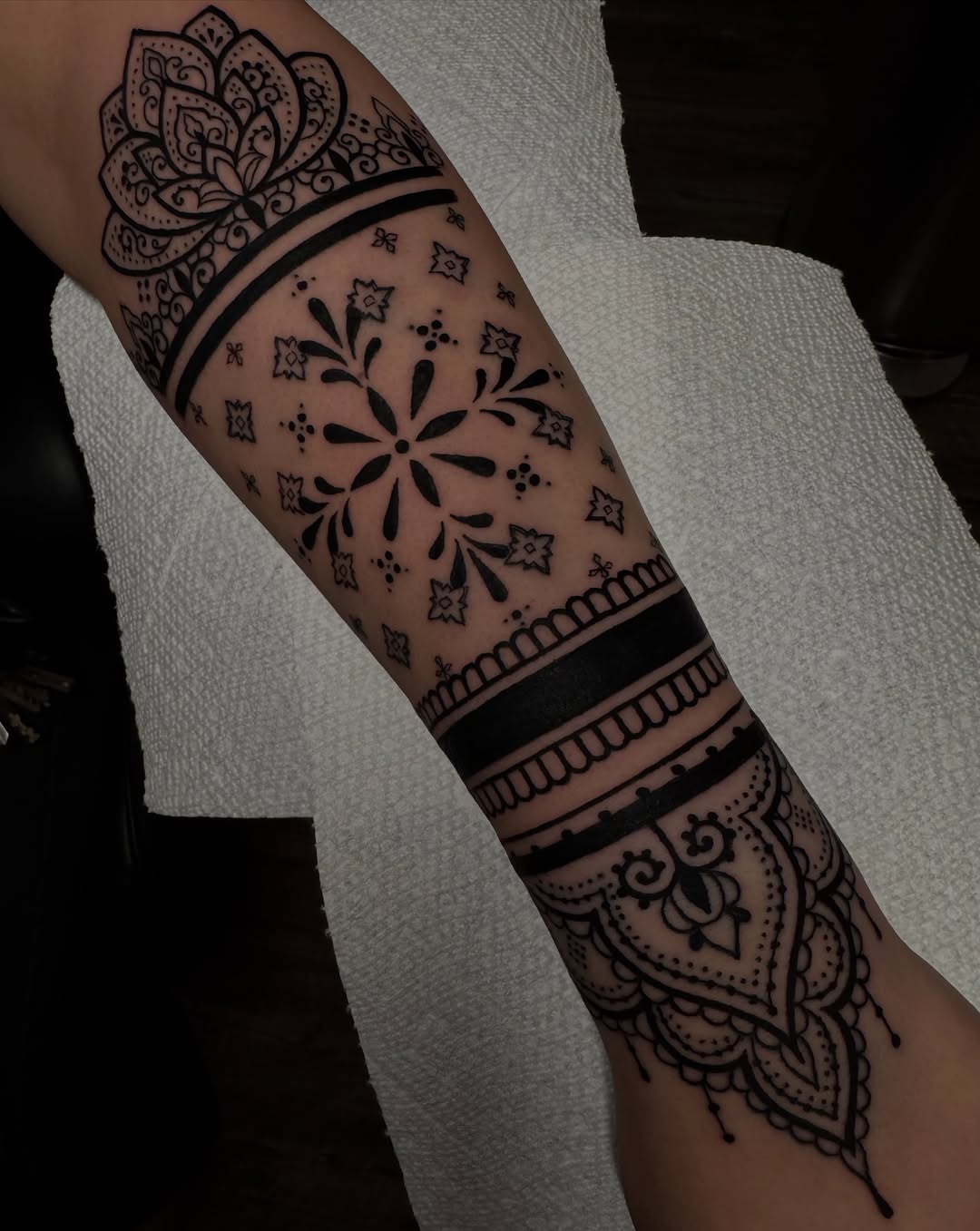 Ornamental band with lotus ornamental tattoo on the forearm by Lisa Nikolopoulos, New York, New York