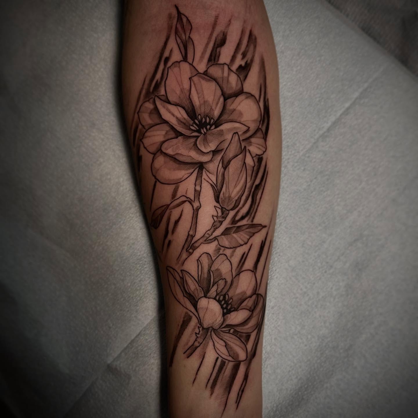 Flowers black and grey tattoo on the forearm by Sebastian Livingston