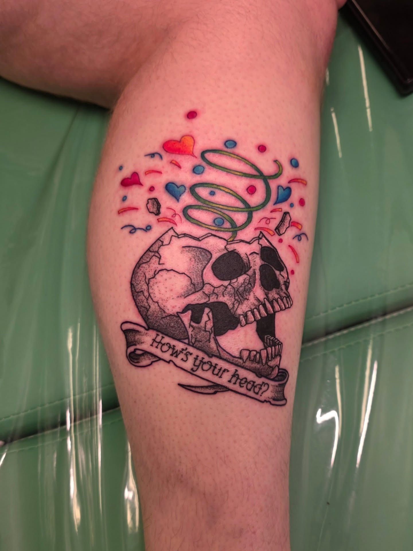 Skull with hearts and banner trash polka tattoo on the thigh by Wray Saulsberry