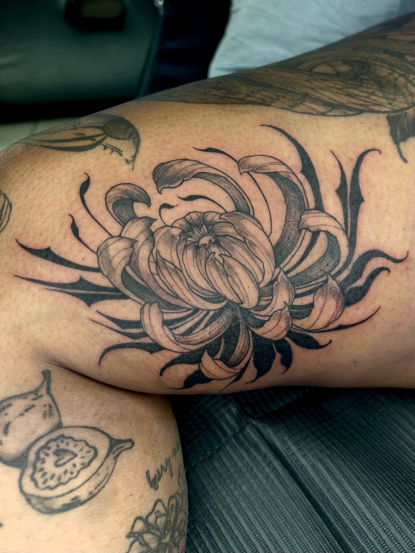 Chrysanthemum black and grey tattoo on the thigh by Magnus