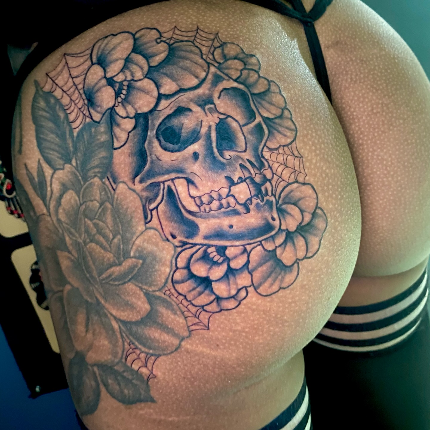 Skull and flowers realism tattoo on the shoulder by Ashley Lin Las Vegas Tattoo Artist