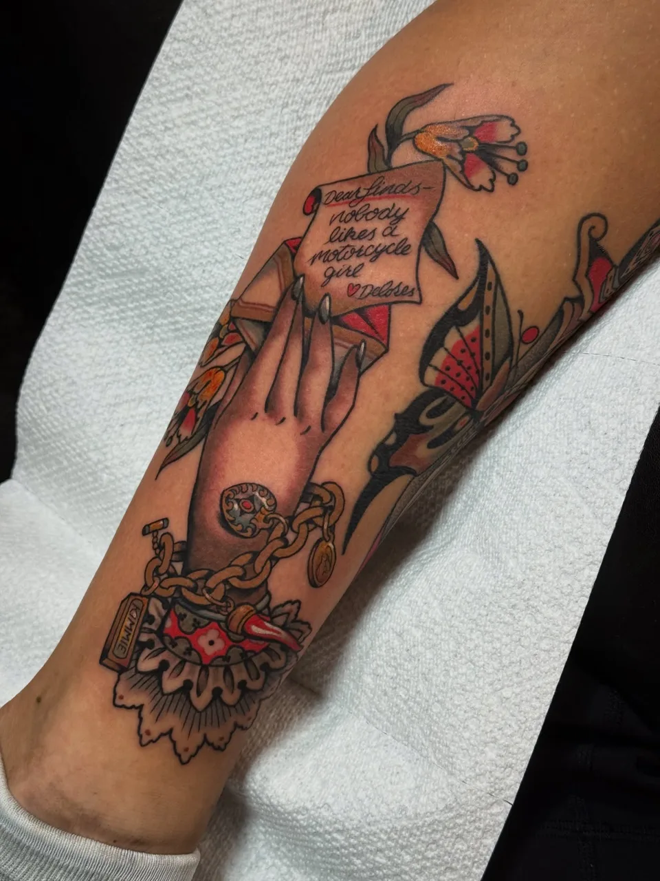 Hand holding letter American traditional tattoo on the forearm by Lauren Vandevier
